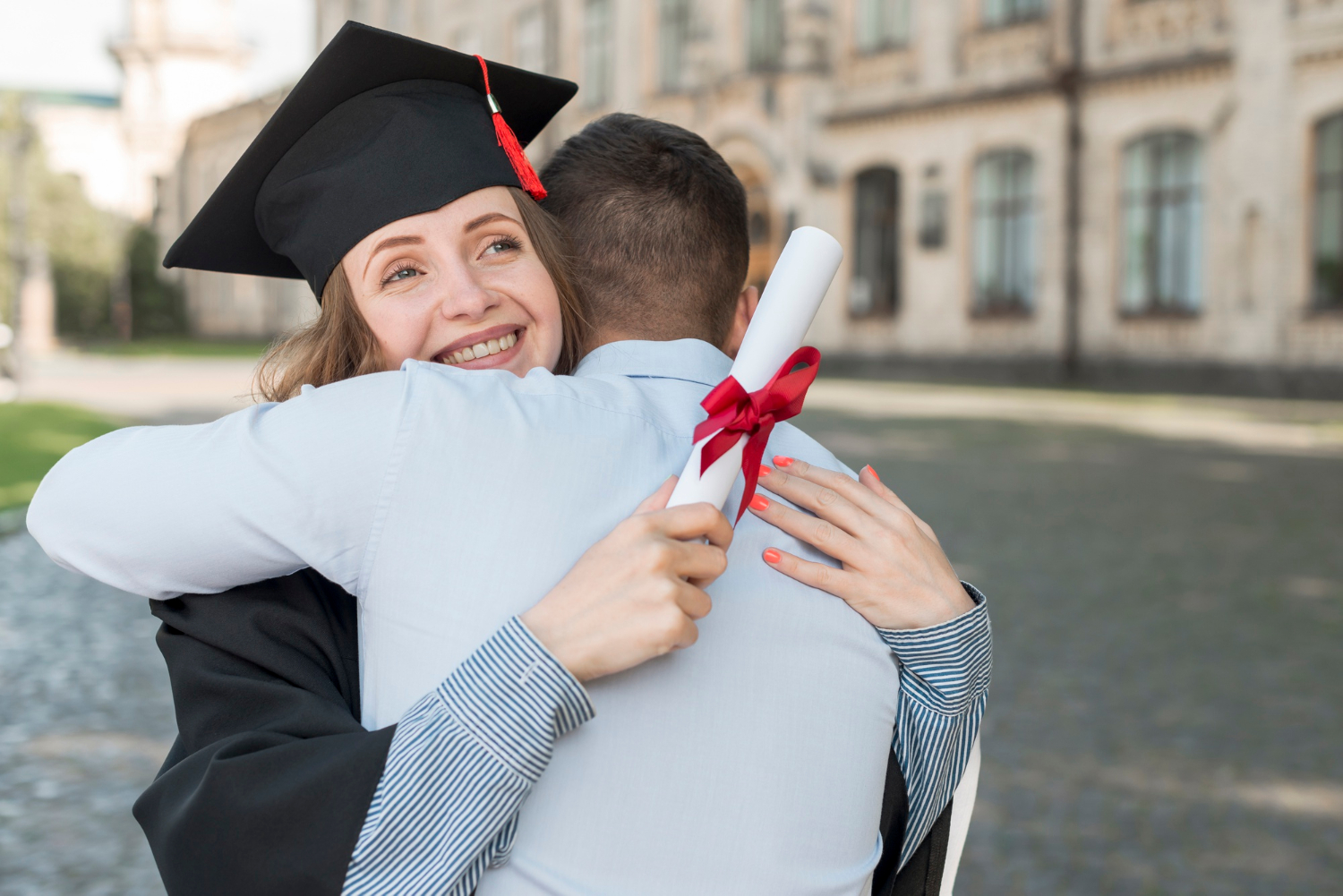 Rodzic przytulający absolwenta studiów